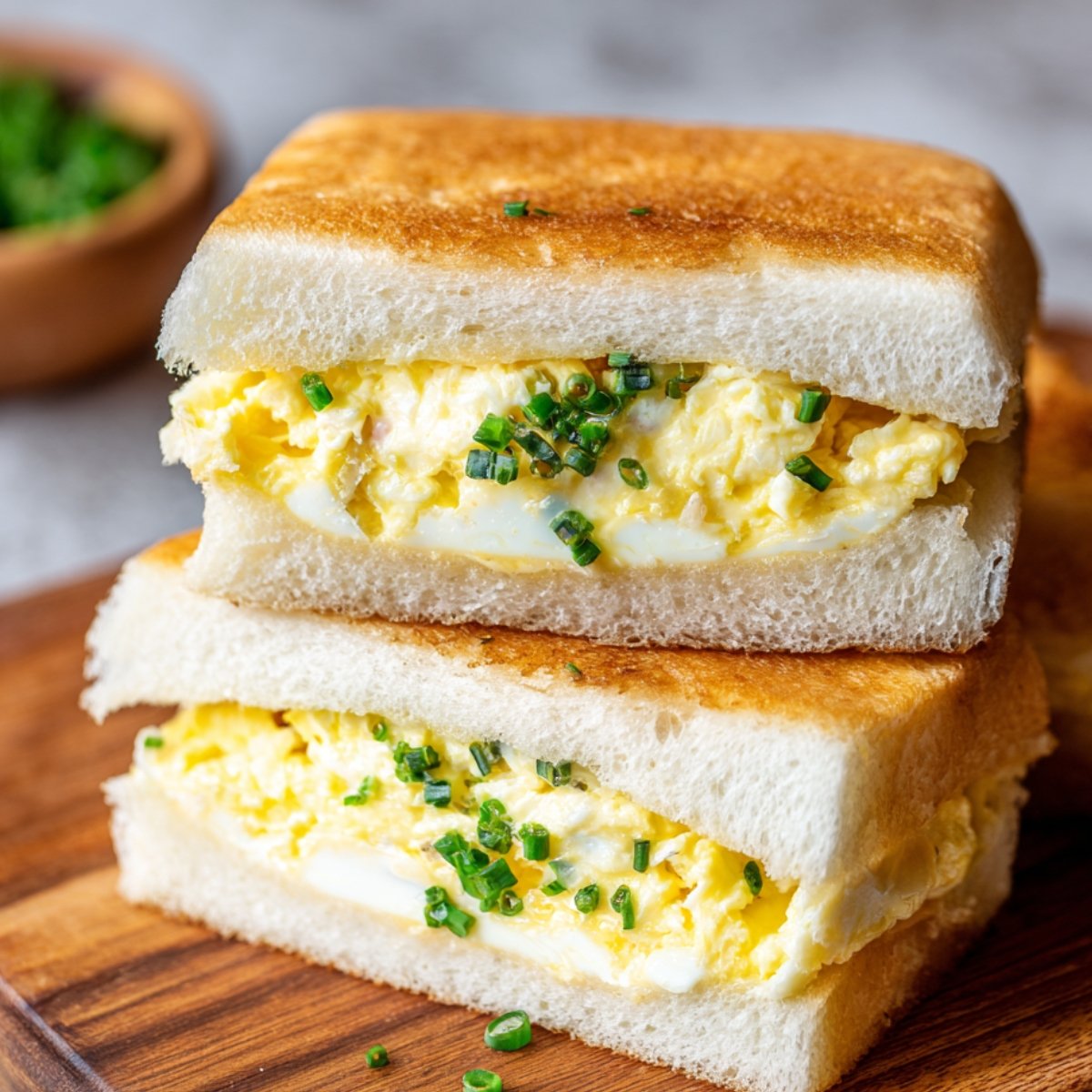 A soft Japanese Egg Sandwich filled with scrambled eggs, showcasing a fluffy, creamy texture between slices of white bread.